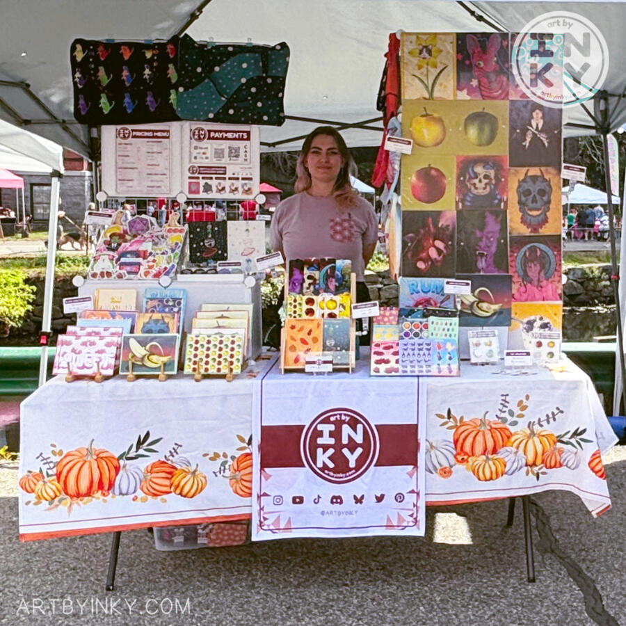 Outside Booth Front Full front view of the booth layout at an outdoor market surrounded by products like art prints, stickers, washi tape tote bags, journals, bookmarks, pins, greeting cards, and coin purses.